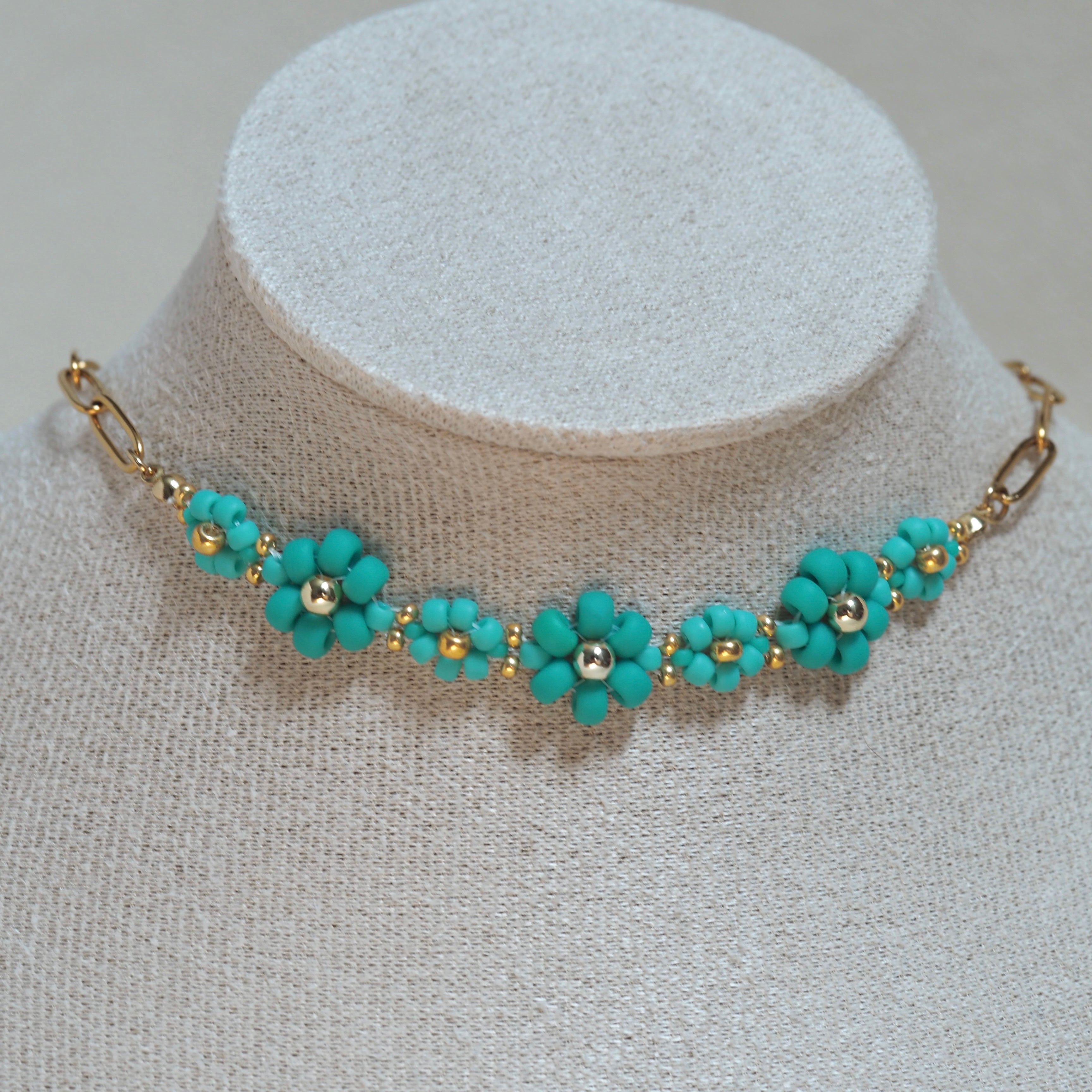 The Urban Petal teal green flower choker necklace on bust display, handmade jewelry Canada
