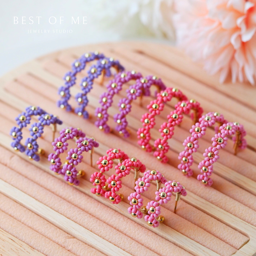 romantic flower hoops earrings in light pink, pink, lilac, and lavender displayed on a white back ground.
