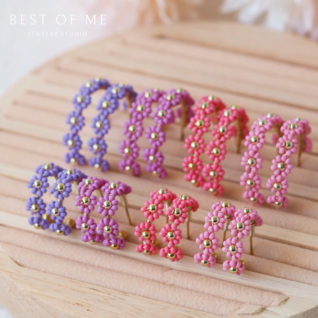 romantic flower hoops earrings in light pink, pink, lilac, and lavender displayed on a white back ground.