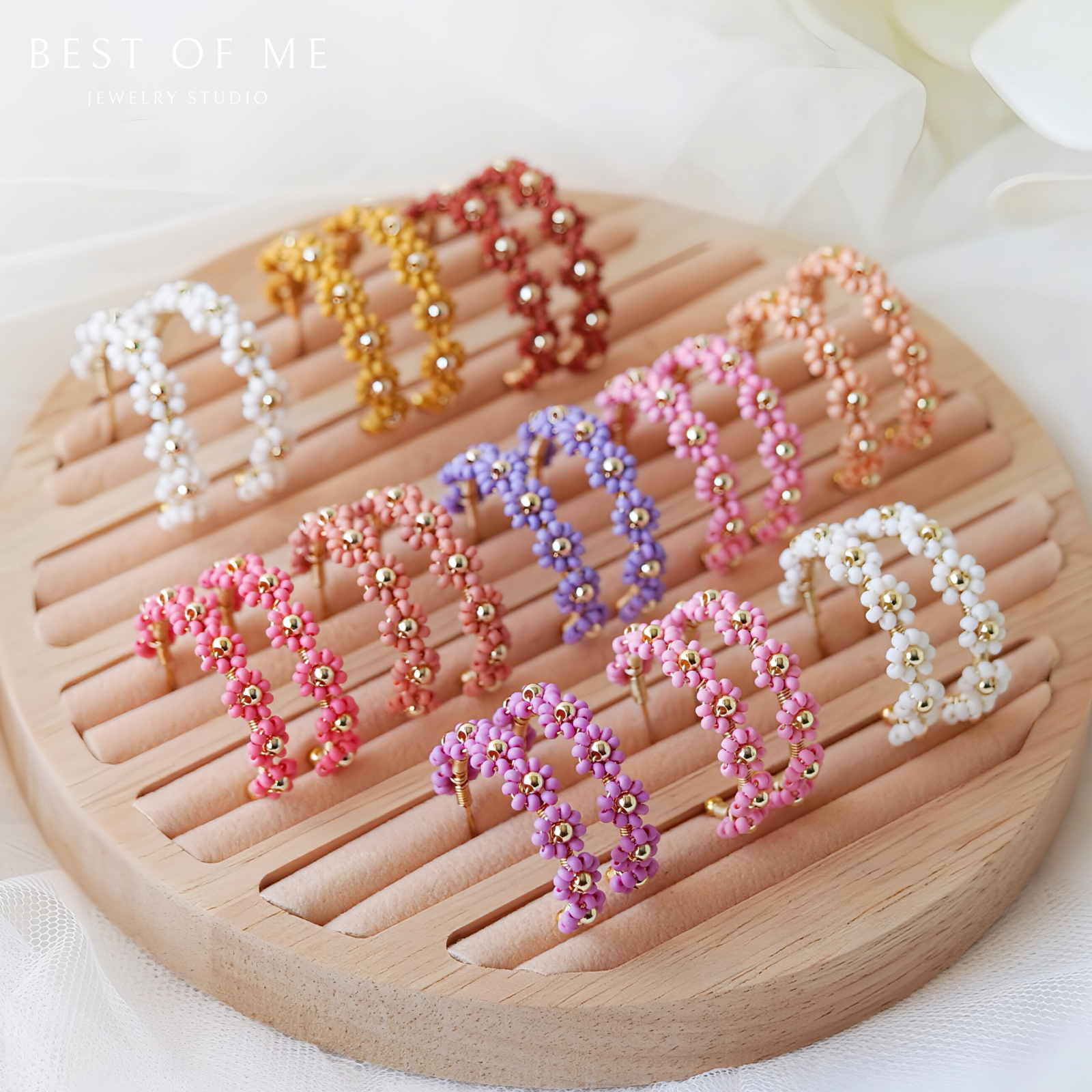 Colorful beaded flower earrings on a wooden stand with 'BEST OF ME' text.