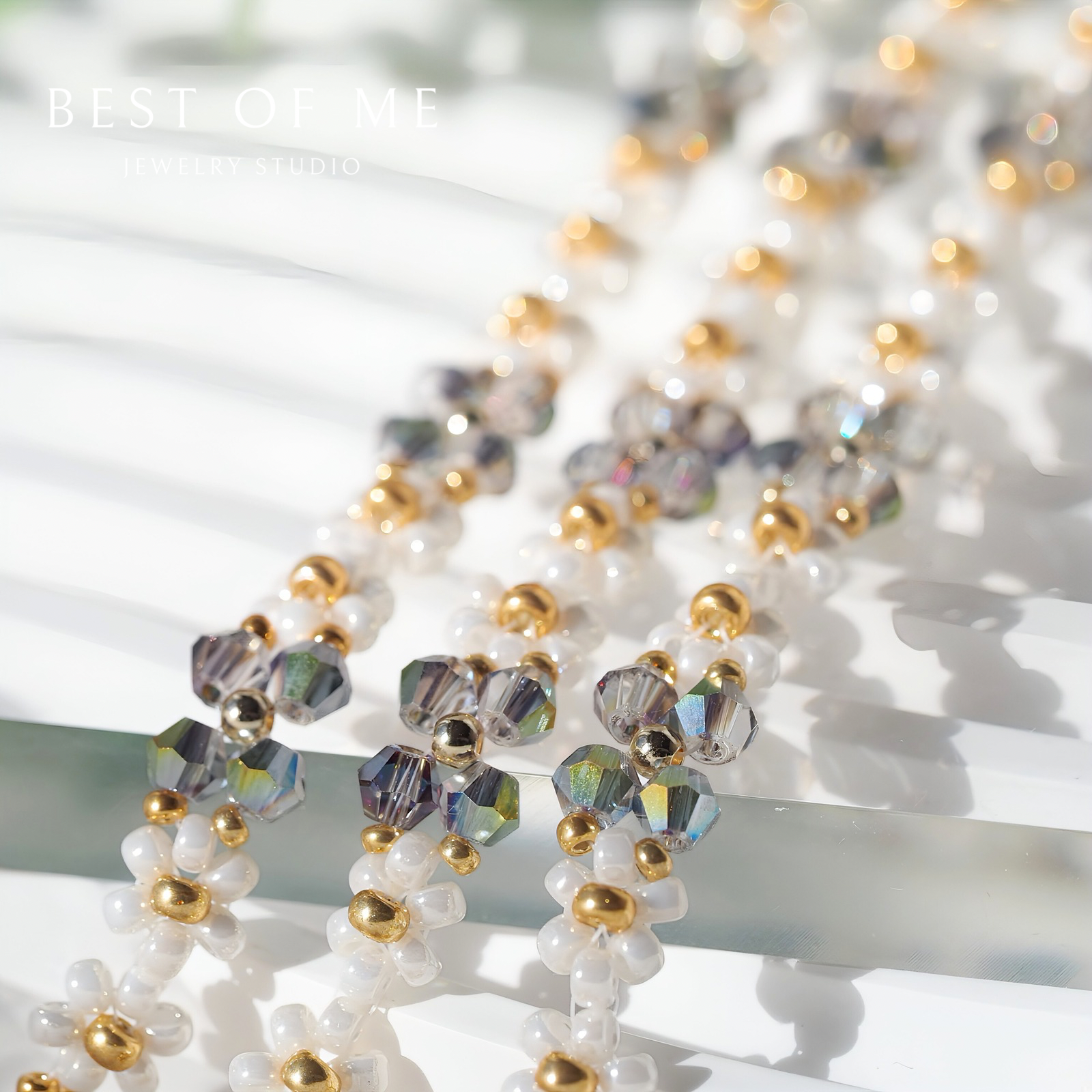 Close-up of a beaded flower bracelet with white, gold, and multicolored beads on a white background.