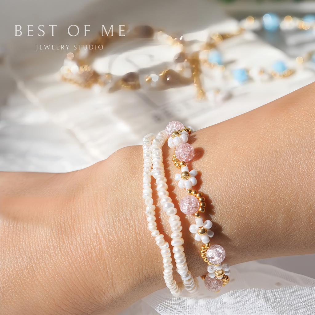 Stack of pearl and beaded flower bracelets on a wrist with 'Best of Me Jewelry Studio' branding.