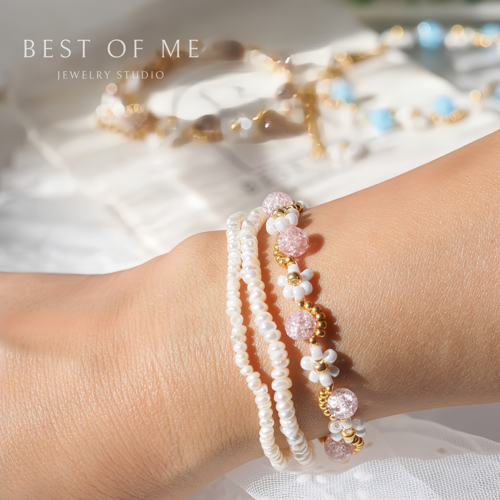 Stack of pearl and beaded flower bracelets on a wrist with 'Best of Me Jewelry Studio' branding.