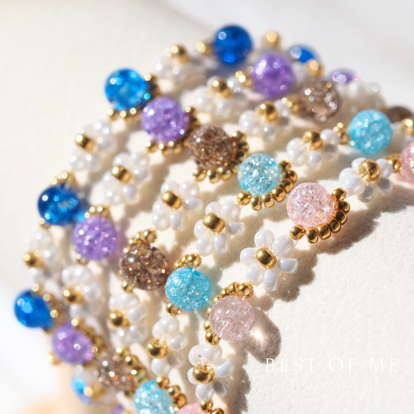 Multicolored beaded handmade bracelet with blue, purple, and pink beads on a white background